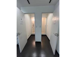 a hallway with white walls and a hallway with doors at Monarch Hotel - Vacation STAY 43004v in Otaru