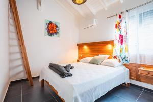Un dormitorio con una cama con un osito de peluche encima. en Villa Alamanda à 1400 m de la mer - Jacuzzi privé, en Sainte-Anne