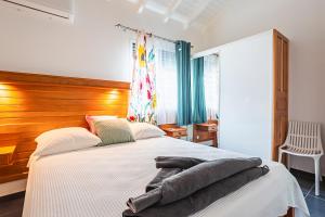 Un dormitorio con una cama grande con cabecero de madera. en Villa Alamanda à 1400 m de la mer - Jacuzzi privé, en Sainte-Anne