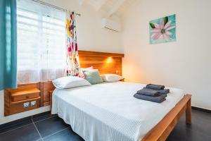 Un dormitorio con una cama con toallas. en Villa Alamanda à 1400 m de la mer - Jacuzzi privé, en Sainte-Anne 4 fotos más