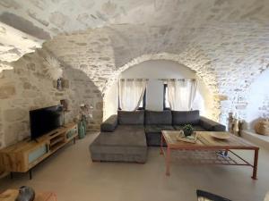 a living room with a couch and a tv at Charmante maison provençale proche d'Uzès in Garrigues-et-Sainte-Eulalie