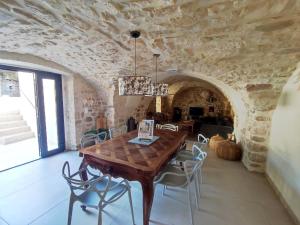 a dining room with a wooden table and chairs at Charmante maison provençale proche d'Uzès in Garrigues-et-Sainte-Eulalie