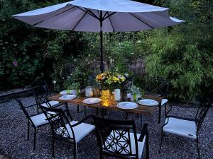 a wooden table with chairs and an umbrella at Cuilcagh Luxury Studio in Enniskillen