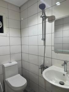 a white bathroom with a toilet and a sink at Elegance suiets hotel Almangaf إليغانس للشقق الفندقية المنقف in Kuwait
