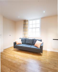 イプスウィッチにあるCozy 2BR 2BATH Apt in Central Ipswich - Sleeps 6 & Prime Locationの窓のあるリビングルームの青いソファ
