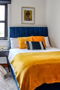 un grande letto con testiera blu in una camera da letto di Spacious Apartment Killorglin Town Centre a Killorglin Altre 19 foto