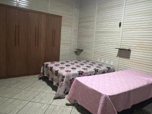 a room with two beds with pink sheets on it at Chacara castanheira in Ariquemes +13 photos
