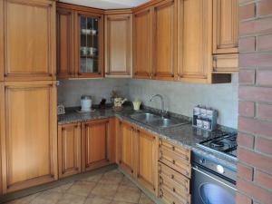 a kitchen with wooden cabinets and a sink at Villetta il Camuciolo in Torre del Lago Puccini