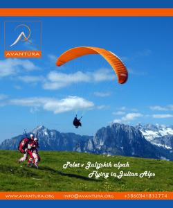 a man is flying a parachute with a helicopter at Sweet Bee Cottage in Bovec