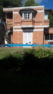 a large brick building with a window and a staircase at Cabañas María CAROLINA in San Luis