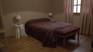 a bedroom with a bed and a table and a window at Cabañas María CAROLINA in San Luis