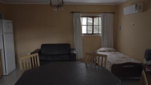 a living room with a table and a chair at Cabañas María CAROLINA in San Luis