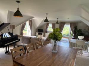 een woonkamer met een tafel en een piano bij Cuilcagh Luxury Apartment in Enniskillen