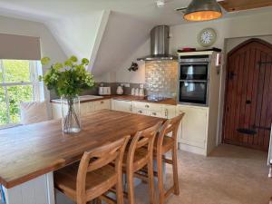 a kitchen with a wooden table and some chairs at Cuilcagh Luxury Apartment in Enniskillen