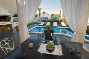 un tavolo con bicchieri da vino e piante su un patio di Villa Sara a Vodice