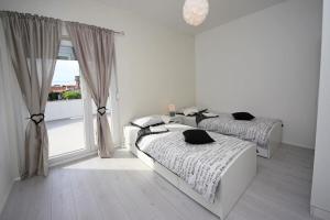 due letti in una stanza bianca con una finestra di Villa Sara a Vodice Altre 36 foto