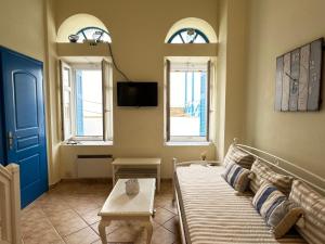 a living room with a couch and two windows at Roula's Suites in Andros