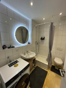 un bagno con lavandino, doccia e WC di Cozy studio apartment a Neuburg an der Donau