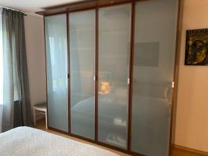 a glass cabinet in a bedroom with a bed at 2-Zimmer - Voll ausgestattet - Ideal für Familien & Gruppen in Munich +1 photo