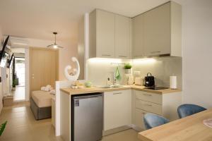 a kitchen with white cabinets and a counter top at Grecian I in Agios Nikolaos