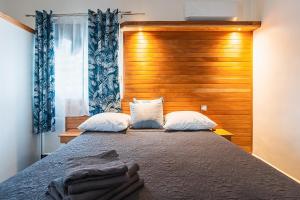 a bedroom with a large bed with a wooden headboard at Villa Plumbago à 1400 m de la mer - piscine in Sainte-Anne