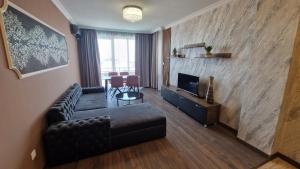 Una sala de estar con un sofá y un televisor. en MitProt Panorama bay 2 Luks Apartment 175, en Sveti Vlas