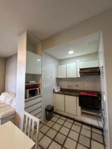 una piccola cucina con armadi bianchi e un letto di 651A golden beira mar 55 m2 a Fortaleza