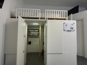 a room with a bunk bed and a white refrigerator at La casina di Stellatattoo in Crotone +7 photos
