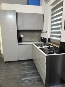 a kitchen with white cabinets and a stove in it at La casina di Stellatattoo in Crotone