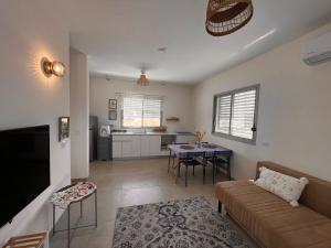 a living room with a couch and a table at הבית של טלי in Kfar Yehezkel