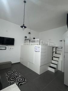 a living room with a kitchen with a counter and stairs at La casina di Stellatattoo in Crotone
