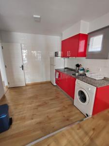 a kitchen with red cabinets and a washing machine at Apartamento la morenuca in Potes +9 photos