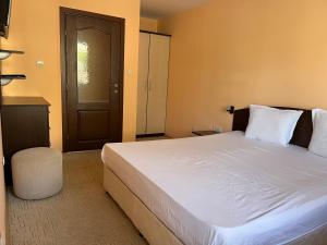 a bedroom with a large white bed and a door at Hotel Silver in Sozopol