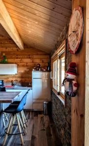 a kitchen with a clock hanging on the wall at Chalet Cosy avec vue imprenable sur le lac in La Celle-sous-Gouzon