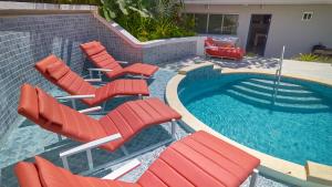a group of red chairs and a swimming pool at AmazINN Places Luxury Villa El Cangrejo in Panama City