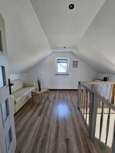 a living room with a couch and a window at Zagajka SUN in Sarbinowo