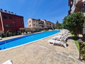Una piscina con tumbonas al lado de un edificio. en MitProt Panorama bay 2 Luks Apartment 175, en Sveti Vlas