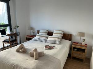 une chambre avec un lit avec deux animaux en peluche dessus dans l'établissement Gandia Playa Moderna - nuevo con piscina y parking, 2 banos, playa 300 m, grau 300 m, à Playa de Gandia 50 autres photos