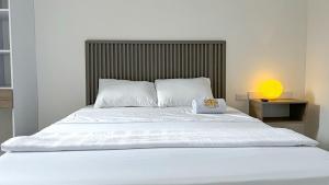 a large white bed with a lamp on a table at Hotel Fuente Real in Popayan