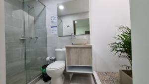a bathroom with a toilet and a sink and a shower at Hotel Fuente Real in Popayan