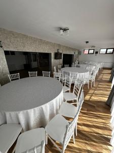a room with white tables and chairs and a room with at Vila Amalia Munții Macinului in Măcin