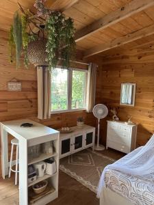 a bedroom with a bed and a desk and a window at Les Lodges de l'Etang in Roquebrune-sur-Argens