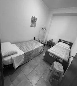 Una foto en blanco y negro de un dormitorio con dos camas. en La casa di Angy, en Terrasini 13 fotos más