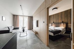 a bedroom with a bed and a living room at PLATiNiUM RESiDENCE GARDEN SASKI - "CENTRUM" in Lublin