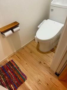 Ein Badezimmer mit Toilette und Teppich auf Holzboden in der Unterkunft Kumano Kodo Private House-CHILL HOUSE-Nachikatsuura in Nachikatsuura