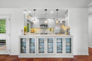 a kitchen with white cabinets and a sink at Alaeloa 35 in Kapalua