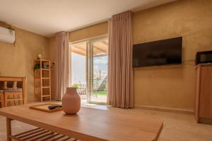 a living room with a table and a large window at הבית של יעל in Zikhron Ya'akov
