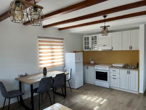 a kitchen with a table and a white refrigerator at Lipovo Mountain House in Kolašin