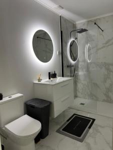 a bathroom with a toilet and a sink and a shower at Casa Carvalho in Peso da Régua