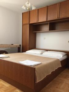 a bedroom with a large bed with wooden cabinets at Apartments Antonia in Malinska